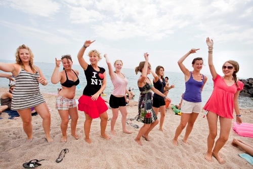 Der eingeuebte Clubtanz, der die Teilnehmer der Jugendreise verbindet, wird jetzt am Strand praesentiert Malgrat de Mar - Clubtanz am Strand