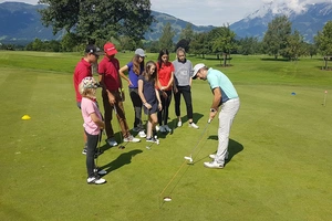 Jugendliche beim Golf Training mit Trainer