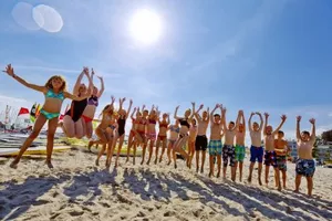 Die Teilnehmer der Jugendreise springen hoch und machen als Gruppe ein Bild an der Ostsee