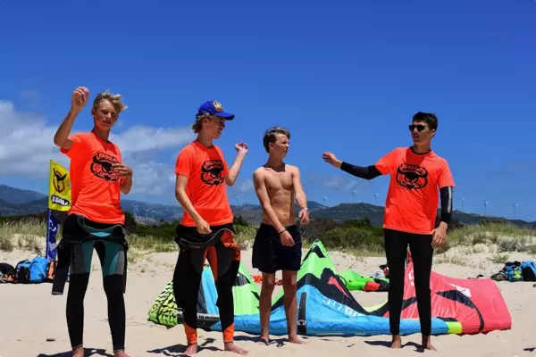 Kite Schüler stehen am Strand und testen die Windrichtung