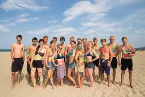 Eine Gruppe Jugendlicher steht gemeinsam am Strand